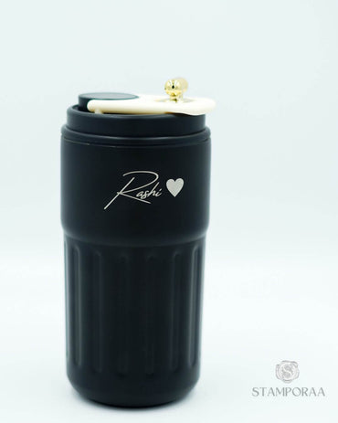 Black tumbler sipper with gold flip lid and 'Kashi' heart logo on side
