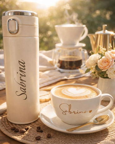 Beige bottle and white mug with gold 'Sabrina' engraving on saucer