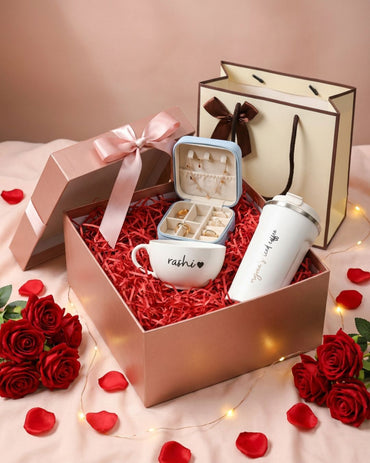 Valentine hamper: open rose-themed box with red filler, mug, and bottle