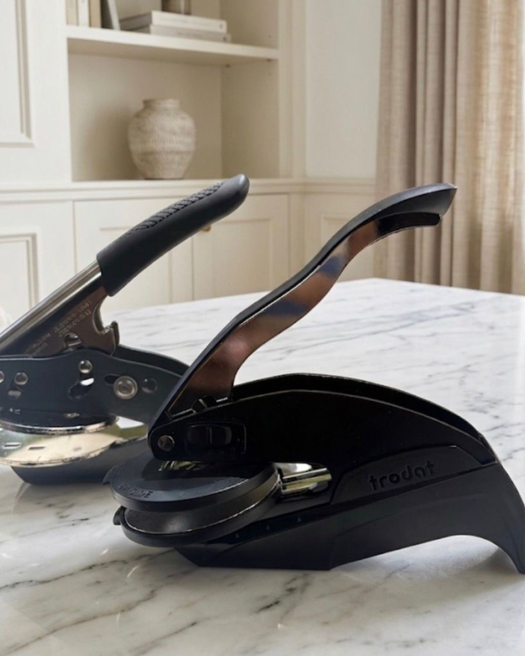Tabletop paper embosser on marble surface, ready to press on paper
