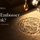 Paper embosser with ink: gold ink drop above a blind embossed seal