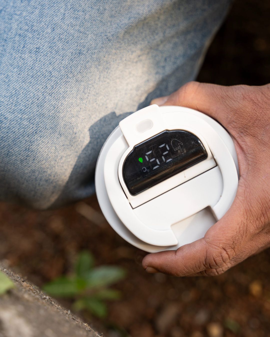 Open-lid view of white smart thermal mug with digital display module