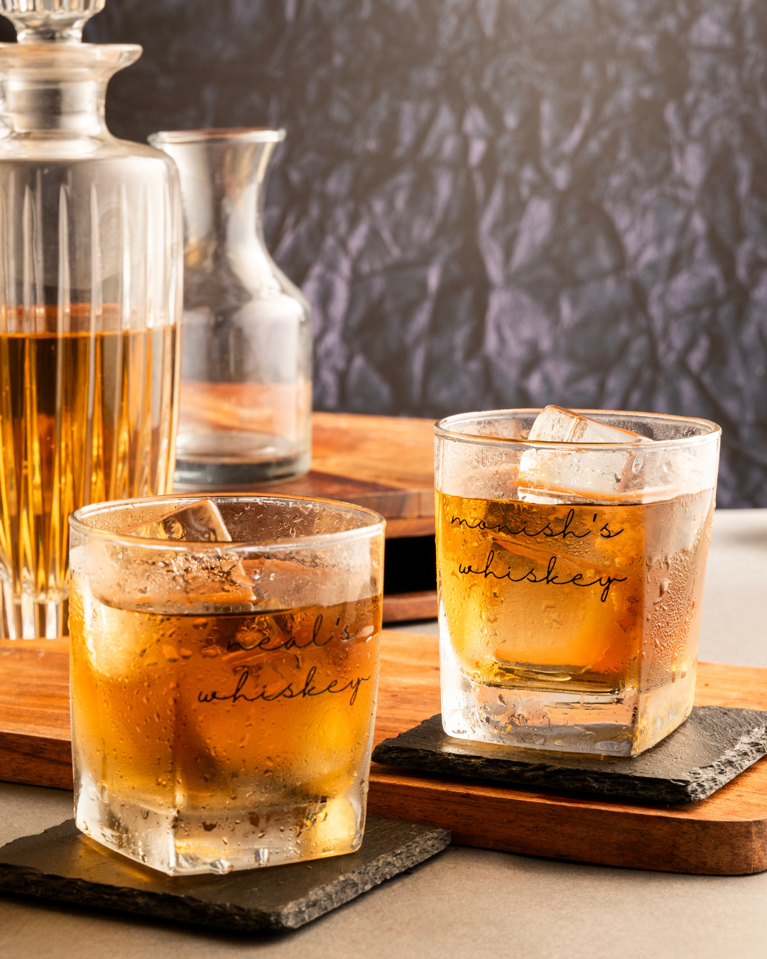 Set of whiskey glasses with amber pour and etched “whiskey” script on clear tumbler