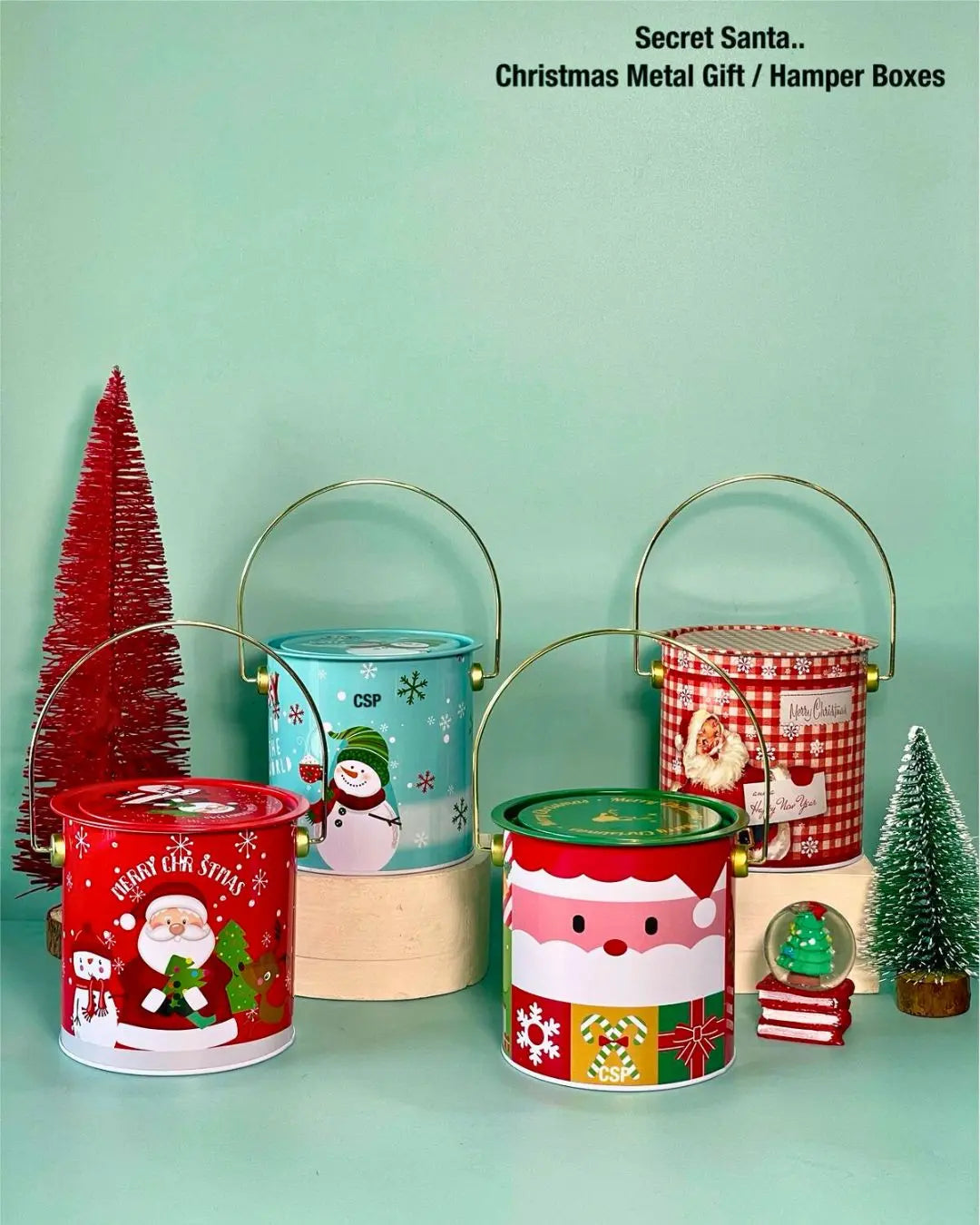 Set of Christmas metal gift buckets in red, blue, and green, with gold handles