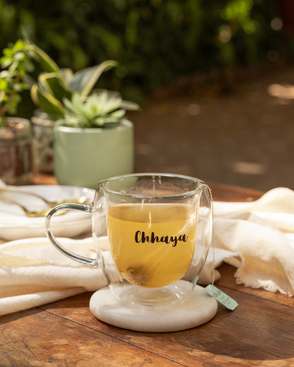 Double Wall Mug mit Henkel und „Chhaya“-Gravur, goldgelber Tee im Glas