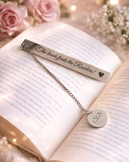 Silver metal bookmark with heart design and round “SD” monogram tag on open book