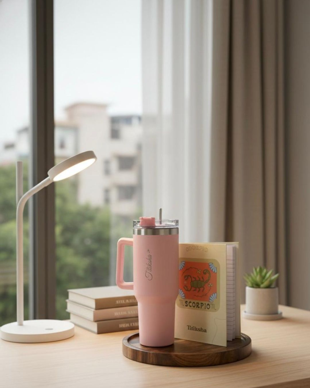 Pink tumbler with handle beside Scorpio journal