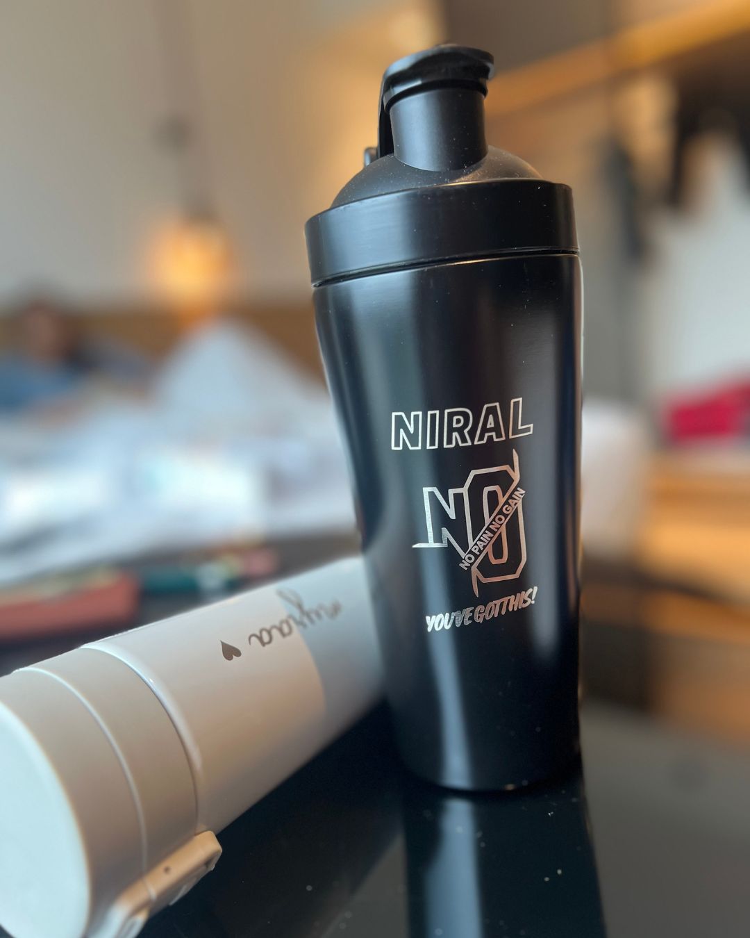 Close-up of matte black shaker bottle with flip-top lid and 'NIRAL' logo