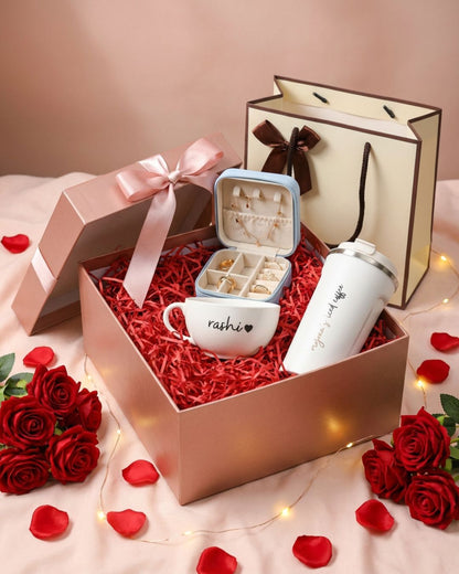 Valentine hamper: open rose-themed box with red filler, mug, and bottle