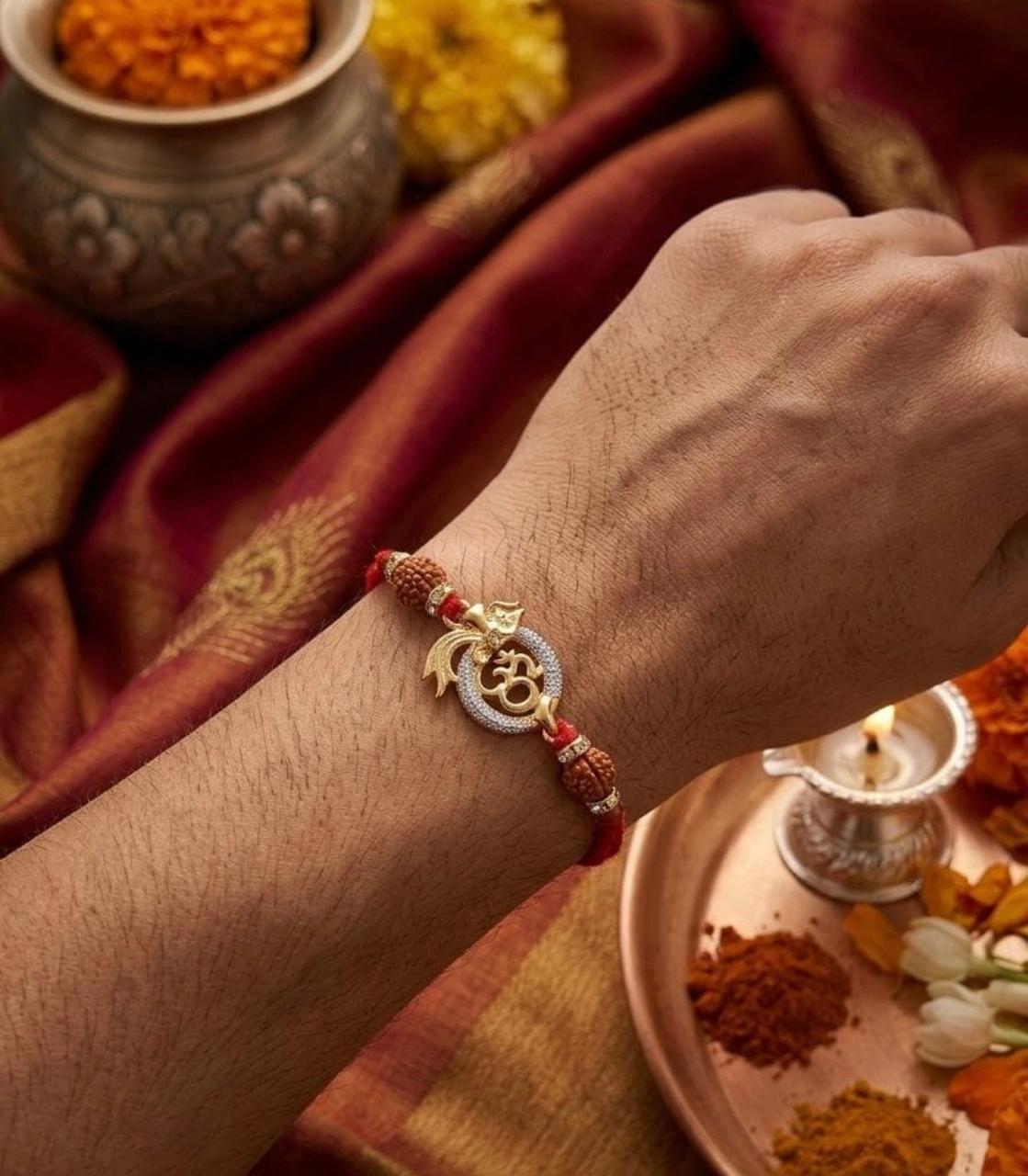 OM Rakhi bracelet on wrist with red thread, gold-toned OM charm, and white beads